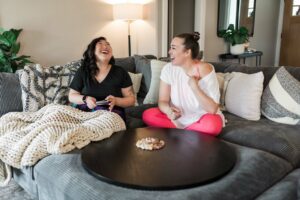 Stephanie and Kat laughing on couch during branding photography session