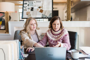 Realtor Ashley and client discussing information on shown on laptop