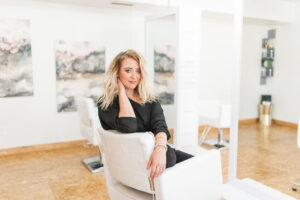 Lavish Beauty Salon owner sitting on chair in a bright and airy setting